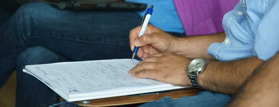 Man's hand writing on a notepad